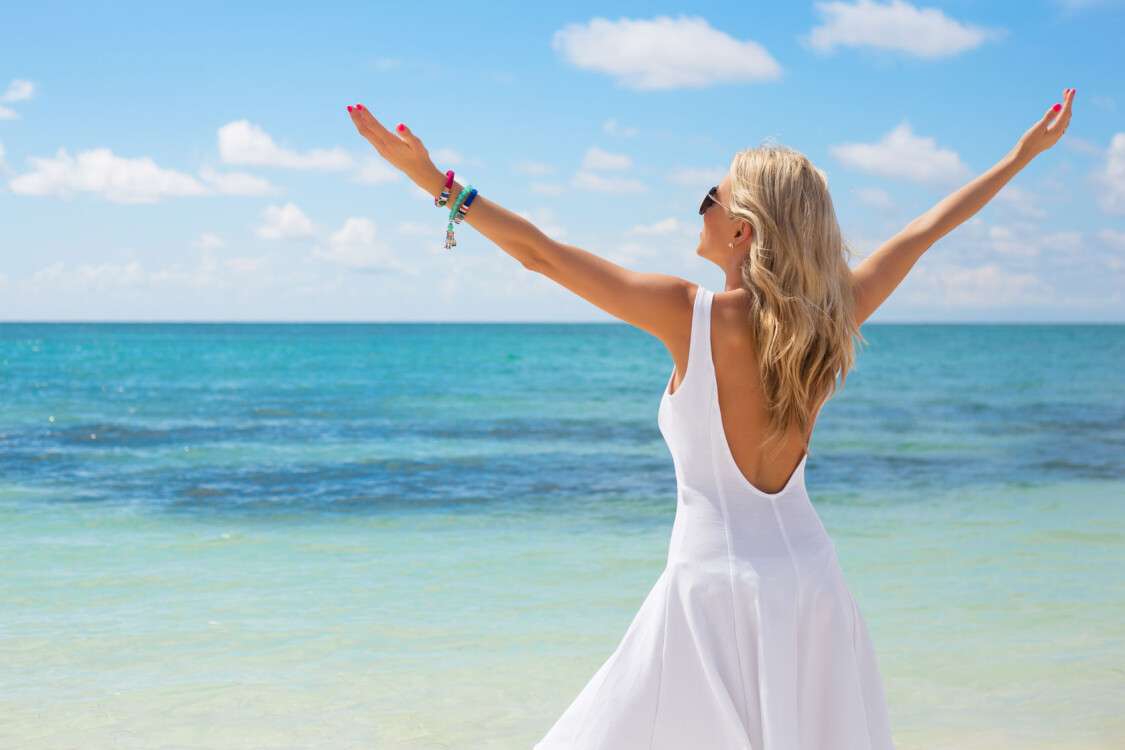 39639744 - young woman in white dress enjoying summer day on the beach