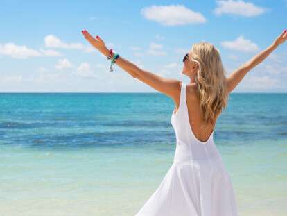 39639744 - young woman in white dress enjoying summer day on the beach