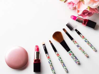 Make up products and tools with pink roses flowers on white