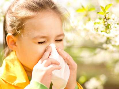 Little girl is blowing her nose