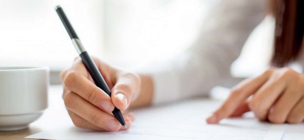 hand-of-businesswoman-writing-on-paper-in-office_1262-2119