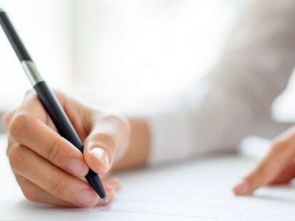 hand-of-businesswoman-writing-on-paper-in-office_1262-2119