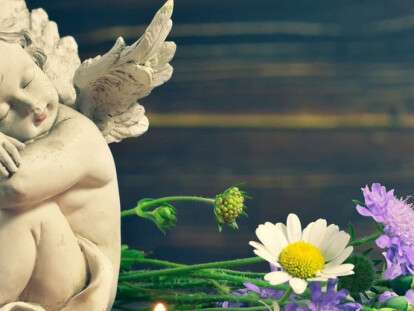 Angel, candle and wildflowers