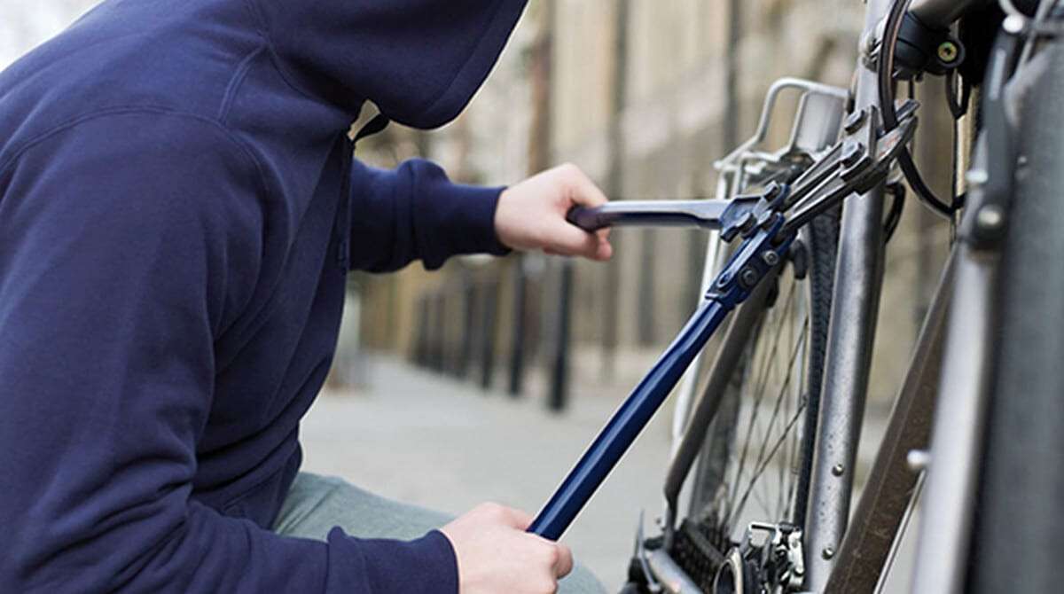 A thief stealing a bike --- Image by © Image Source/Corbis