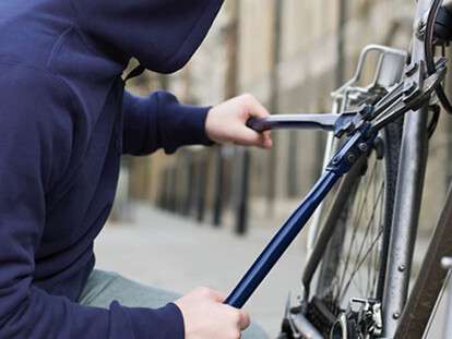A thief stealing a bike --- Image by © Image Source/Corbis