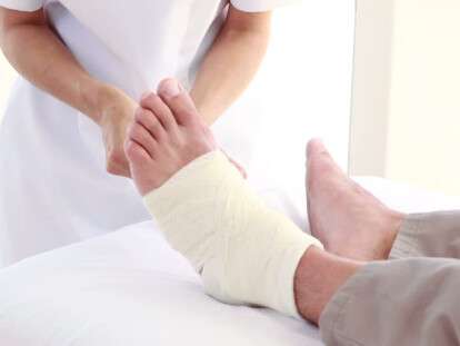 746116194-bandaging-ankle-wrapping-massage-table
