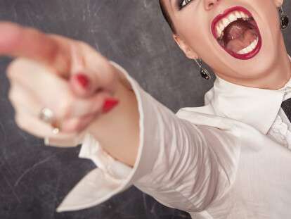 Angry screaming woman in white blouse pointing out