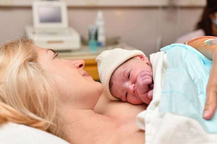 Mom and newborn baby skin to the skin after birth in the hospital