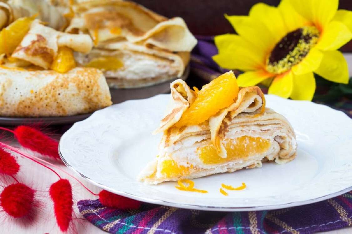 Pancake cake with oranges, whipped cream, delicious breakfast on