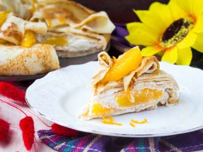 Pancake cake with oranges, whipped cream, delicious breakfast on
