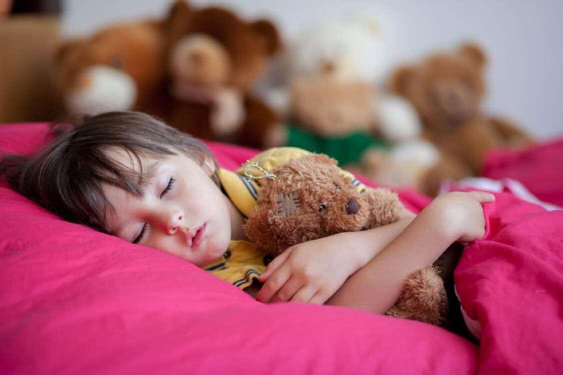 Sweet little boy, sleeping in the afternoon with his teddy bear