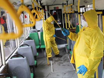 Employees sanitize a bus in Lviv