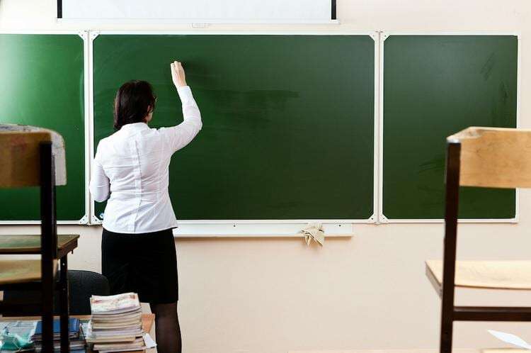 Teacher writing on the blackboard