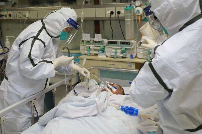 Medical staff in protective suits treat a patient with pneumonia caused by the new coronavirus at the Zhongnan Hospital of Wuhan University, in Wuhan