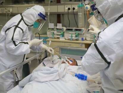 Medical staff in protective suits treat a patient with pneumonia caused by the new coronavirus at the Zhongnan Hospital of Wuhan University, in Wuhan