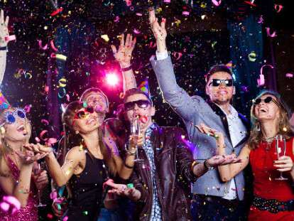 Cheerful young people showered with confetti on a club party.
