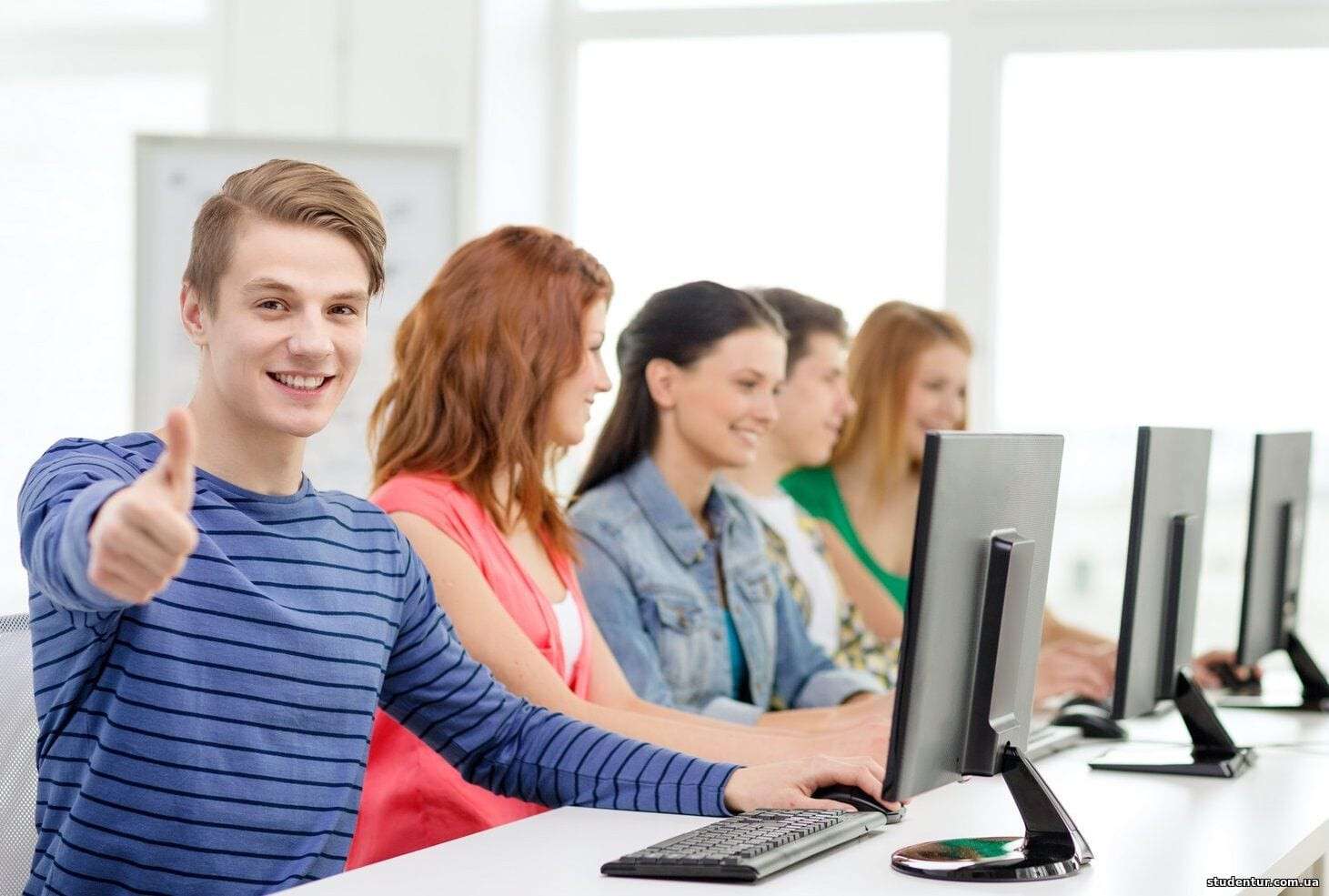 male student with classmates in computer class