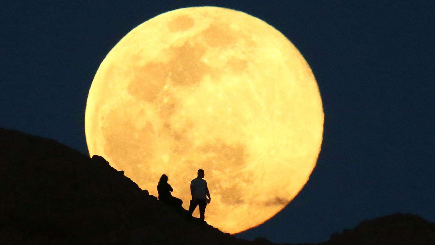 The supermoon, also known as the pink moon rises over the Papago Park Buttes on Apr. 7, 2020 in Phoenix, Ariz.  It is the