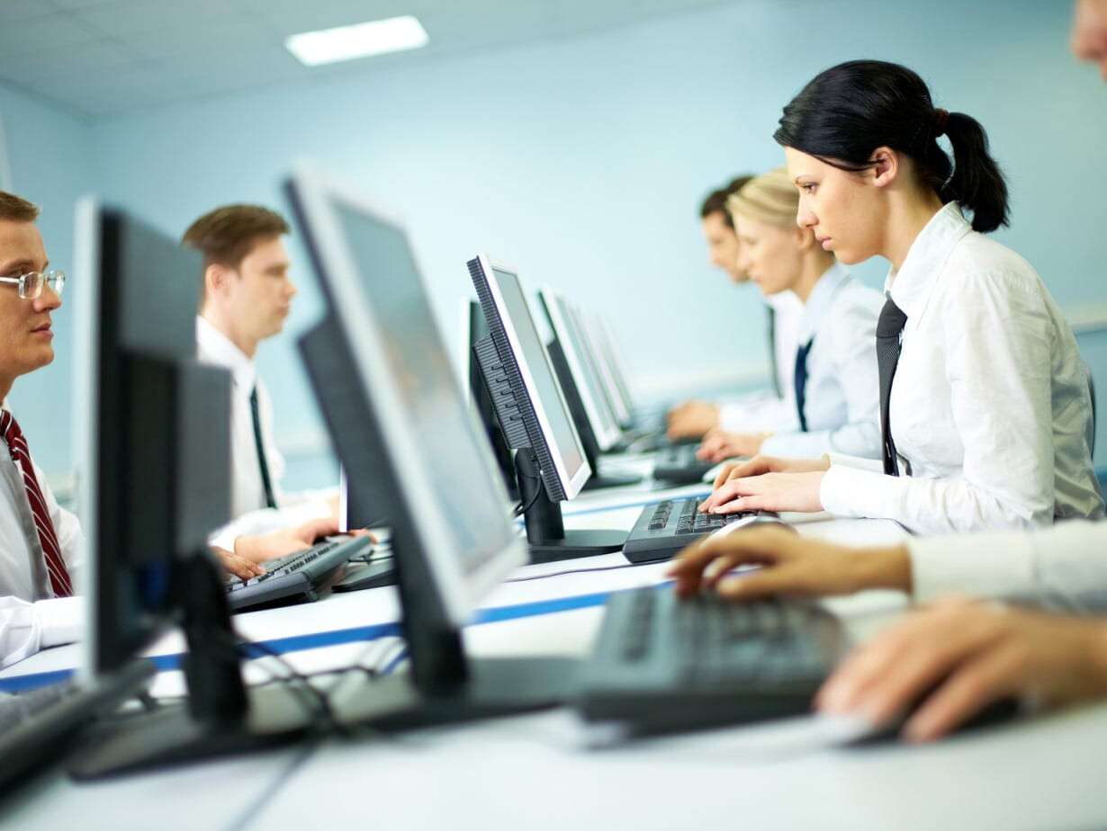 Office with white collar workers working on computers