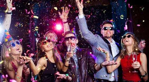 Cheerful young people showered with confetti on a club party.