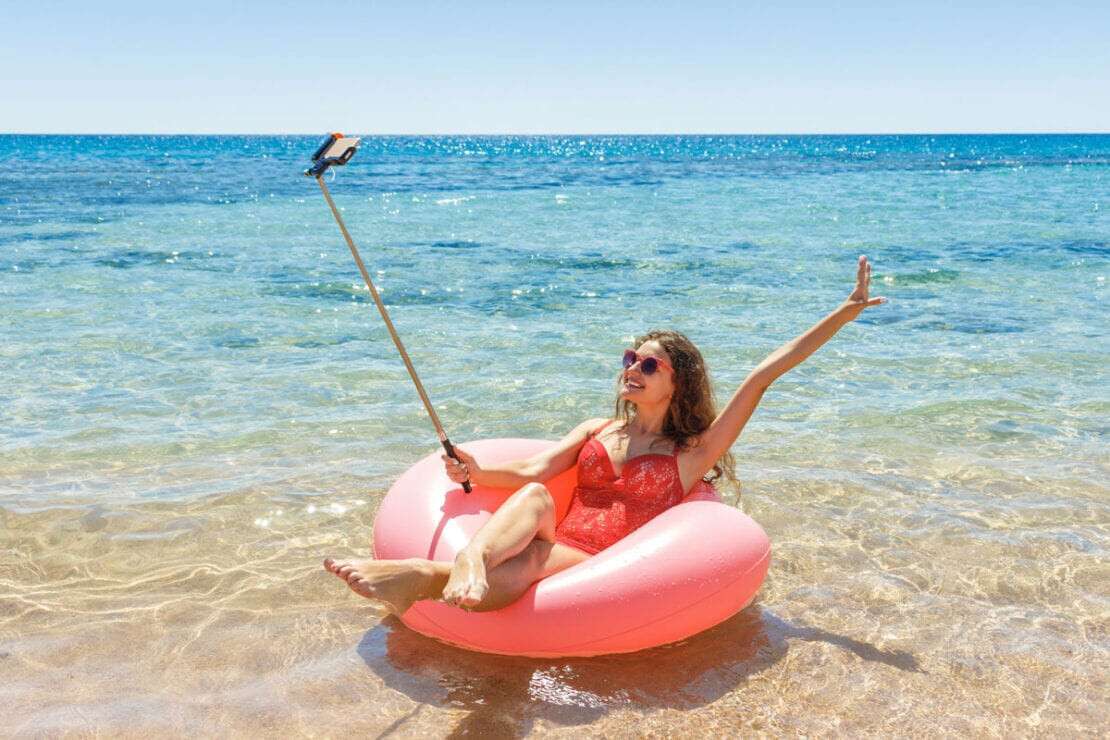 Young Woman Relaxing On Inflatable Ring In Sea During Summer