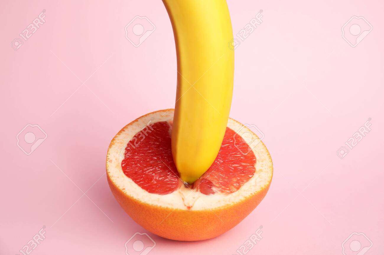 Fresh grapefruit and banana on pink background. Sex concept