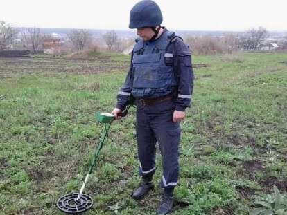ищут мину на огороде