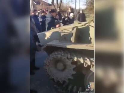 люди останавливают танк