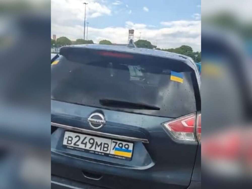 русские заклеивают номера украинским флагом